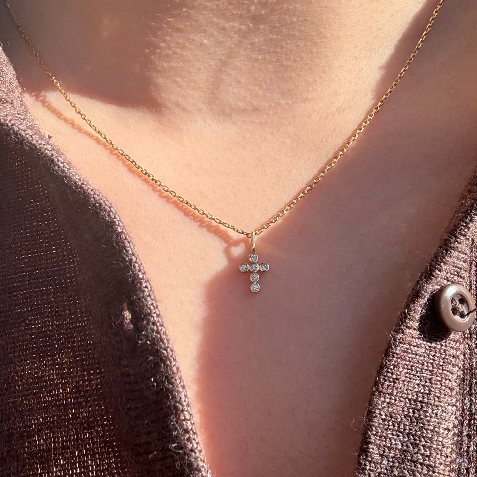 Bezel Kors vedhæng i 18 kt guld med brillantslebne diamanter på 0,06 ct – vist på model