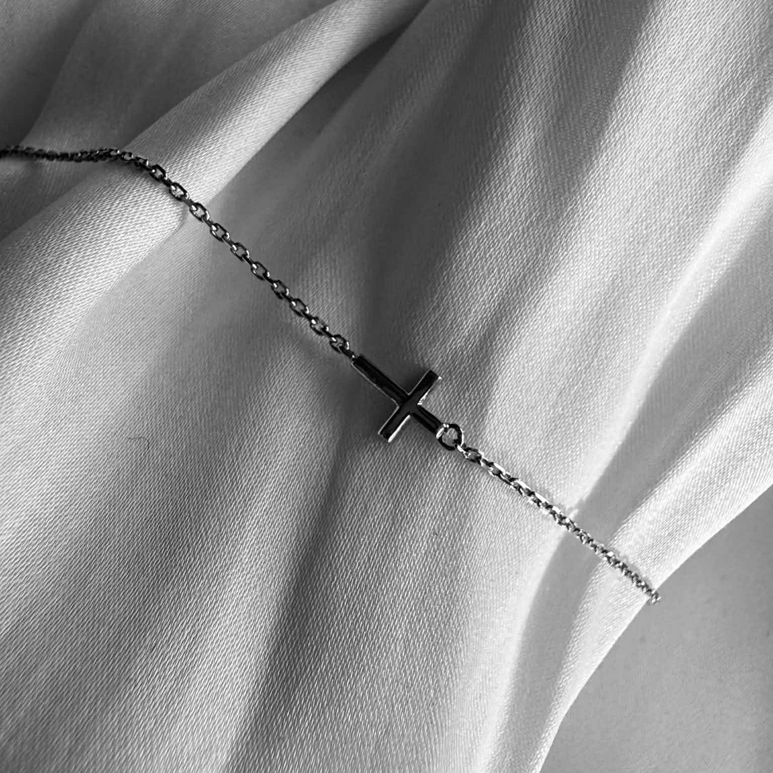 Kors armbånd i 18 kt guld - vist på klæde