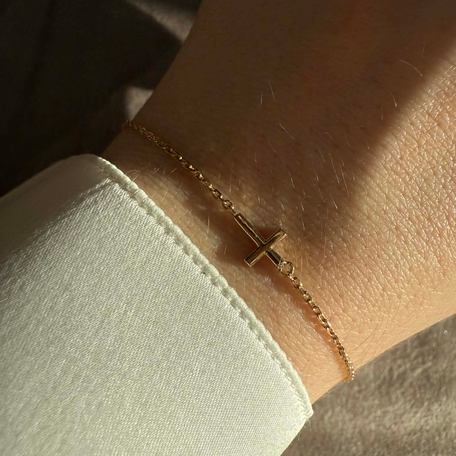 Kors armbånd i 18 kt guld - vist på håndled