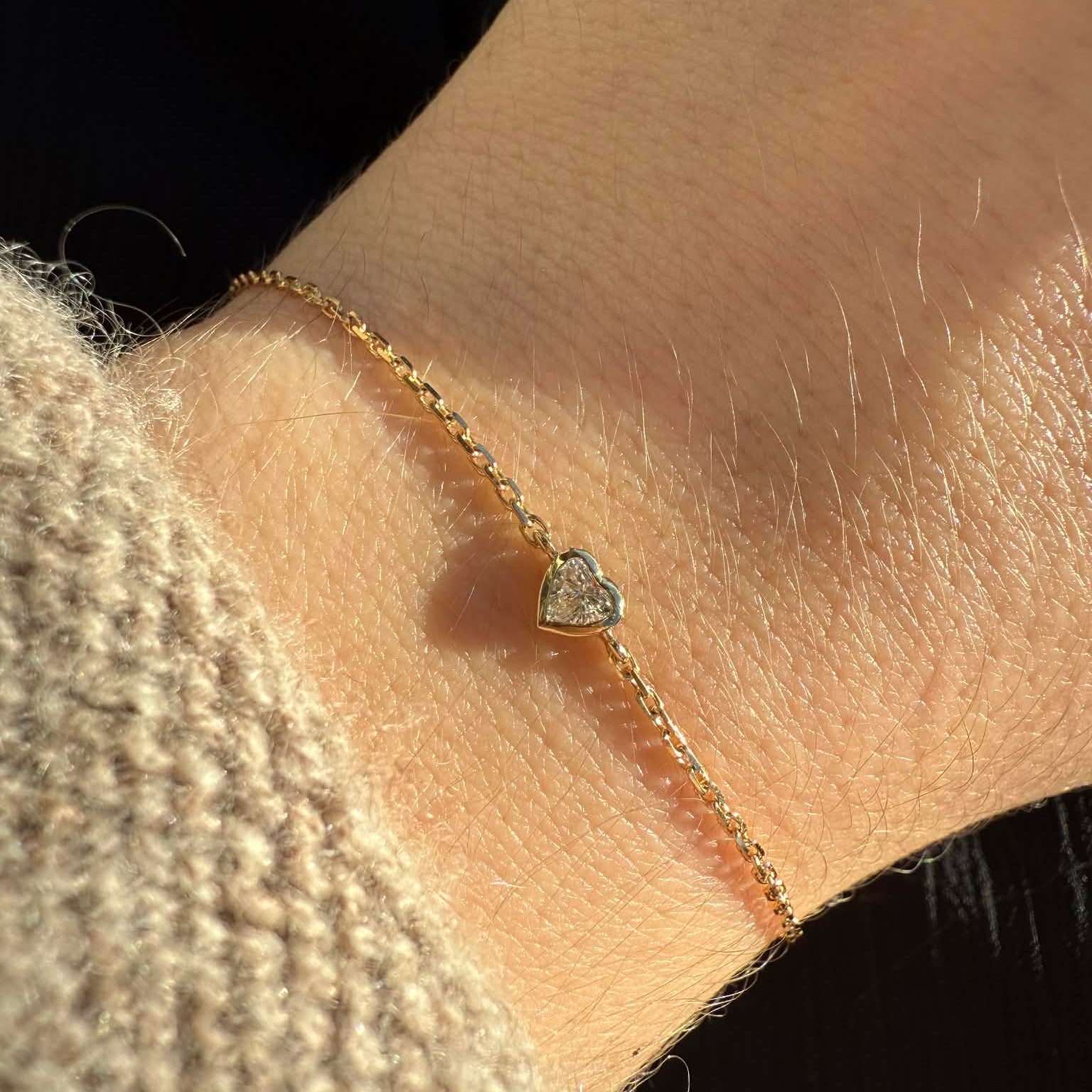 Armbånd i 18 kt guld med hjertesleben diamant – vist på model håndled