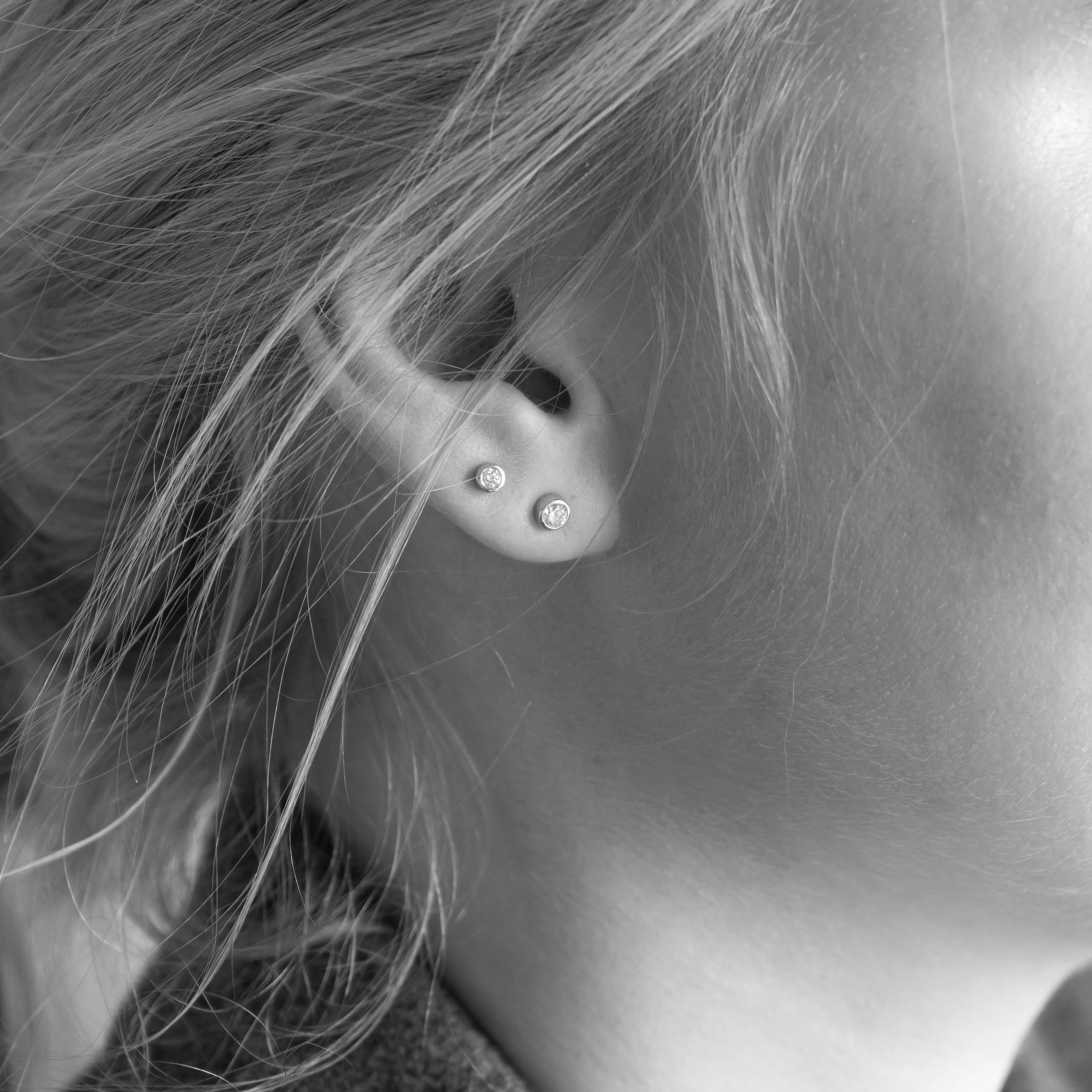 Bezel diamant ørestikker i 18 kt hvidguld – båret på model
