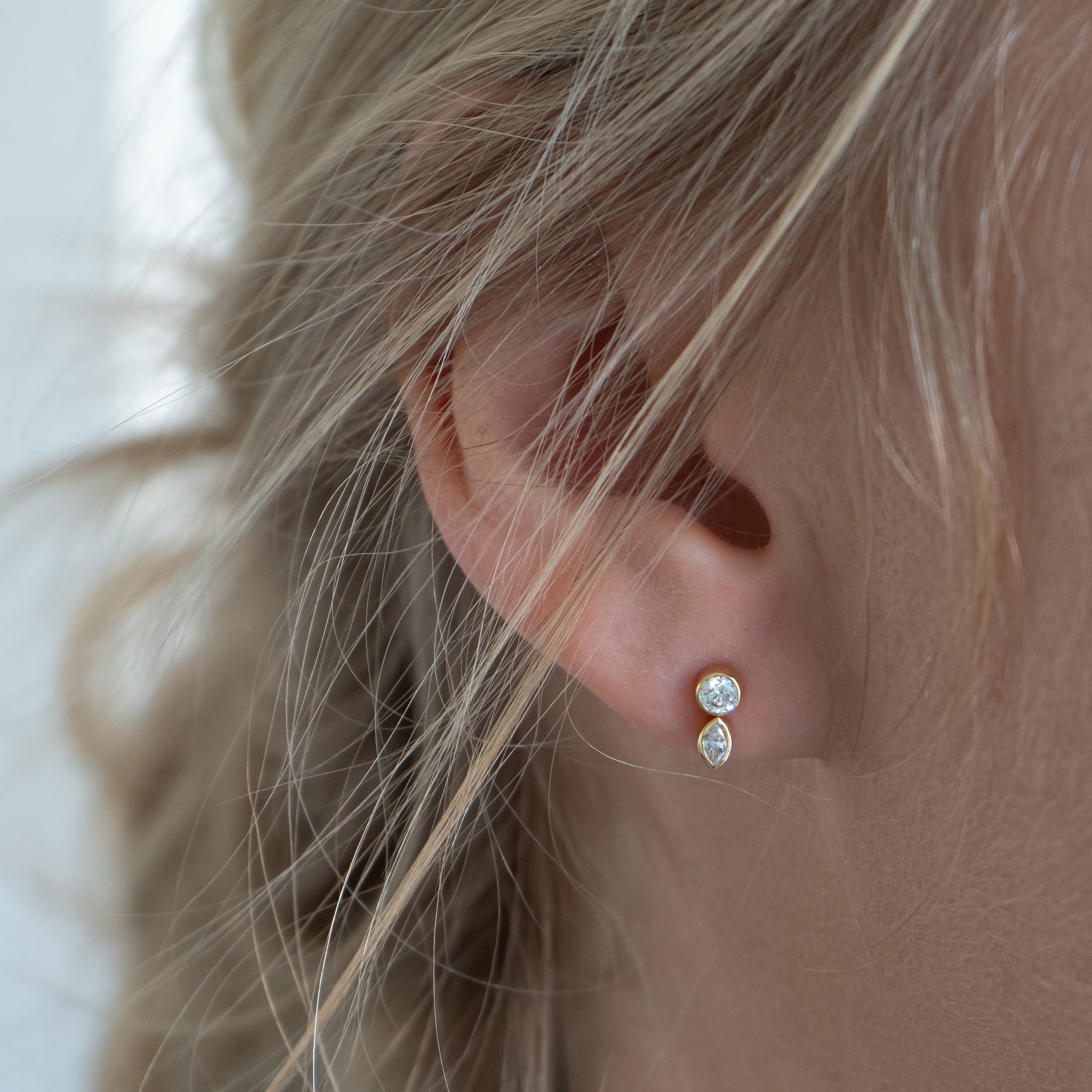 Ørering i 18 kt guld med brillantsleben og marquisesleben diamant – vist på øre