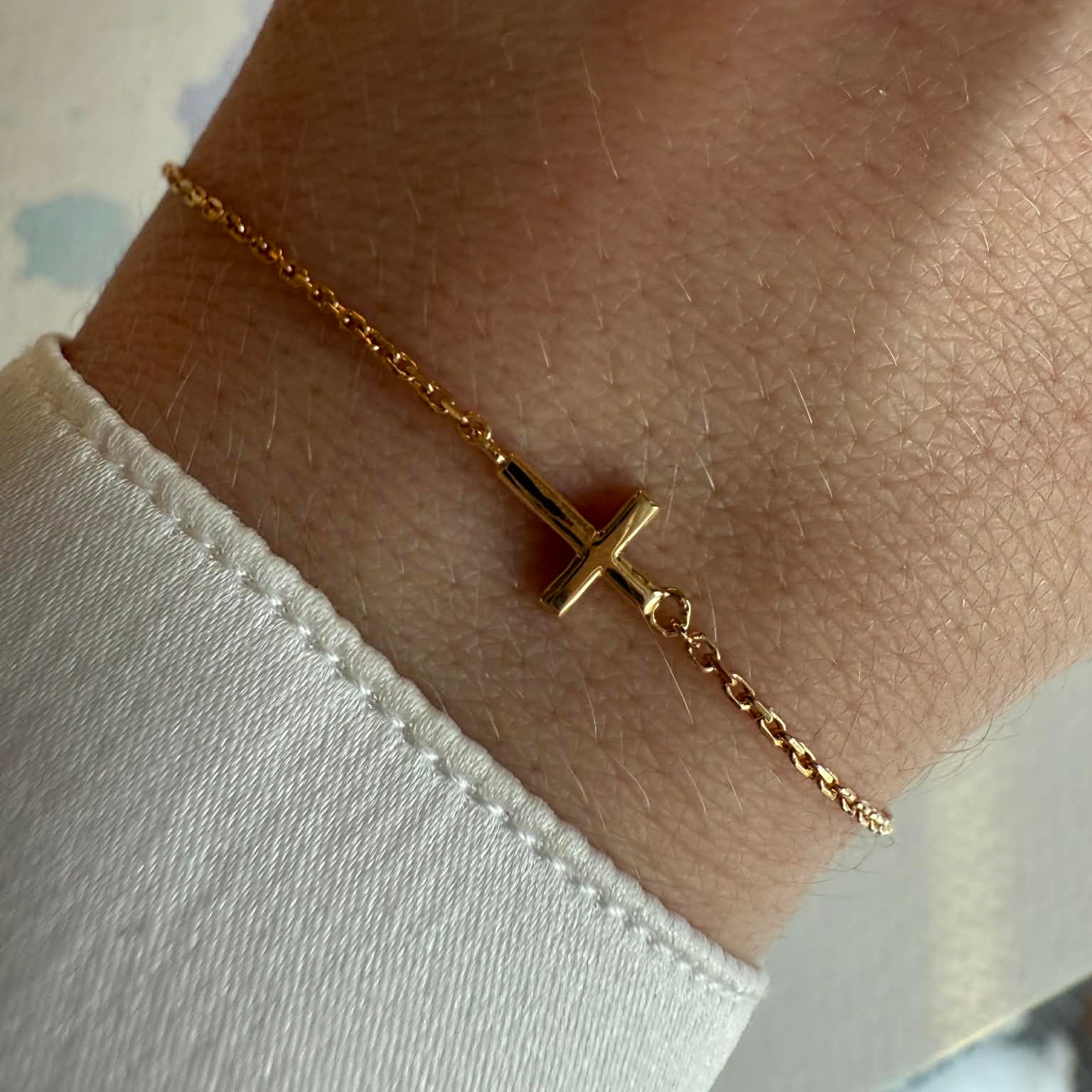 Kors armbånd i 18 kt guld - vist på model