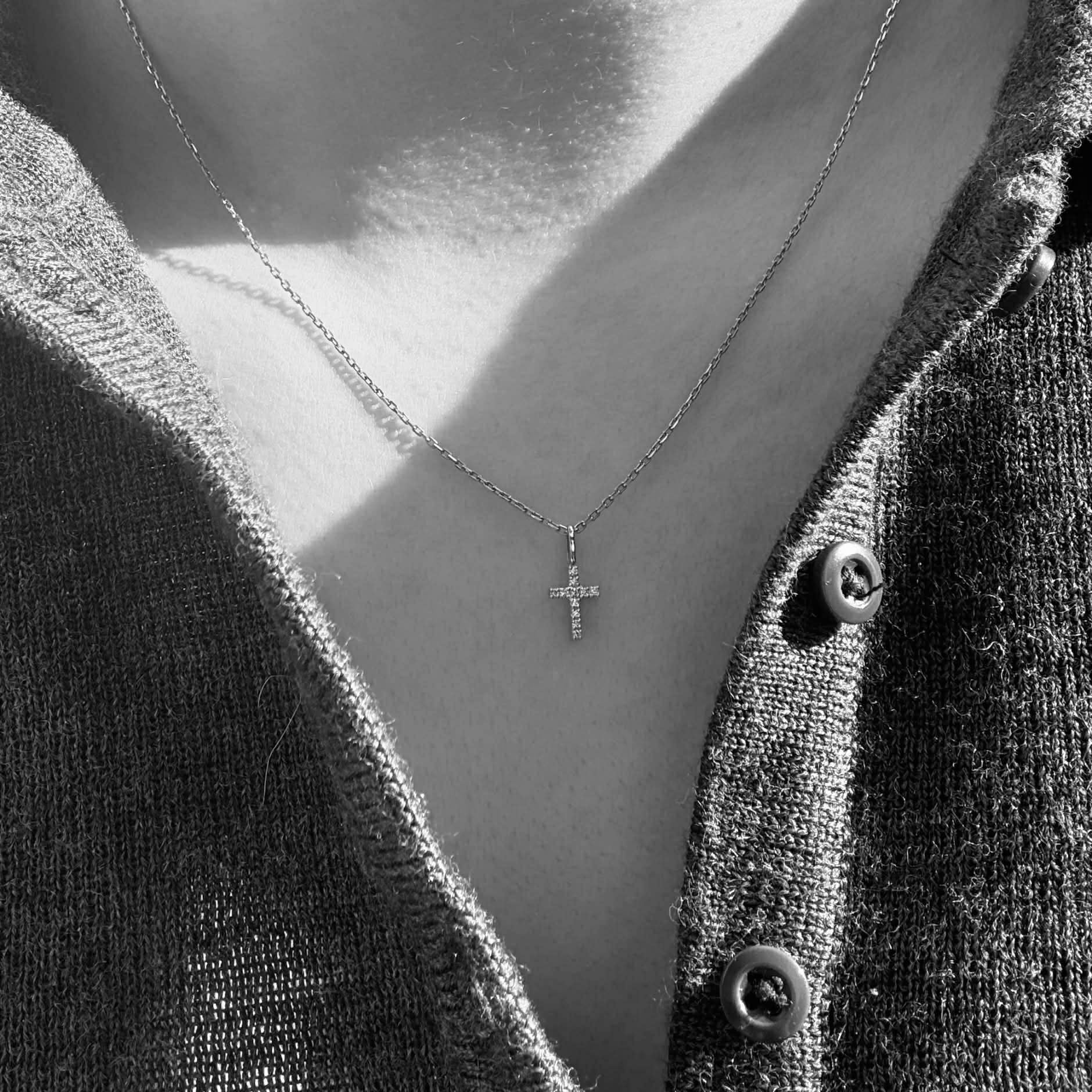 Kors vedhæng i 18 kt hvidguld med brillantslebne diamanter på 0,05 ct – vist på model